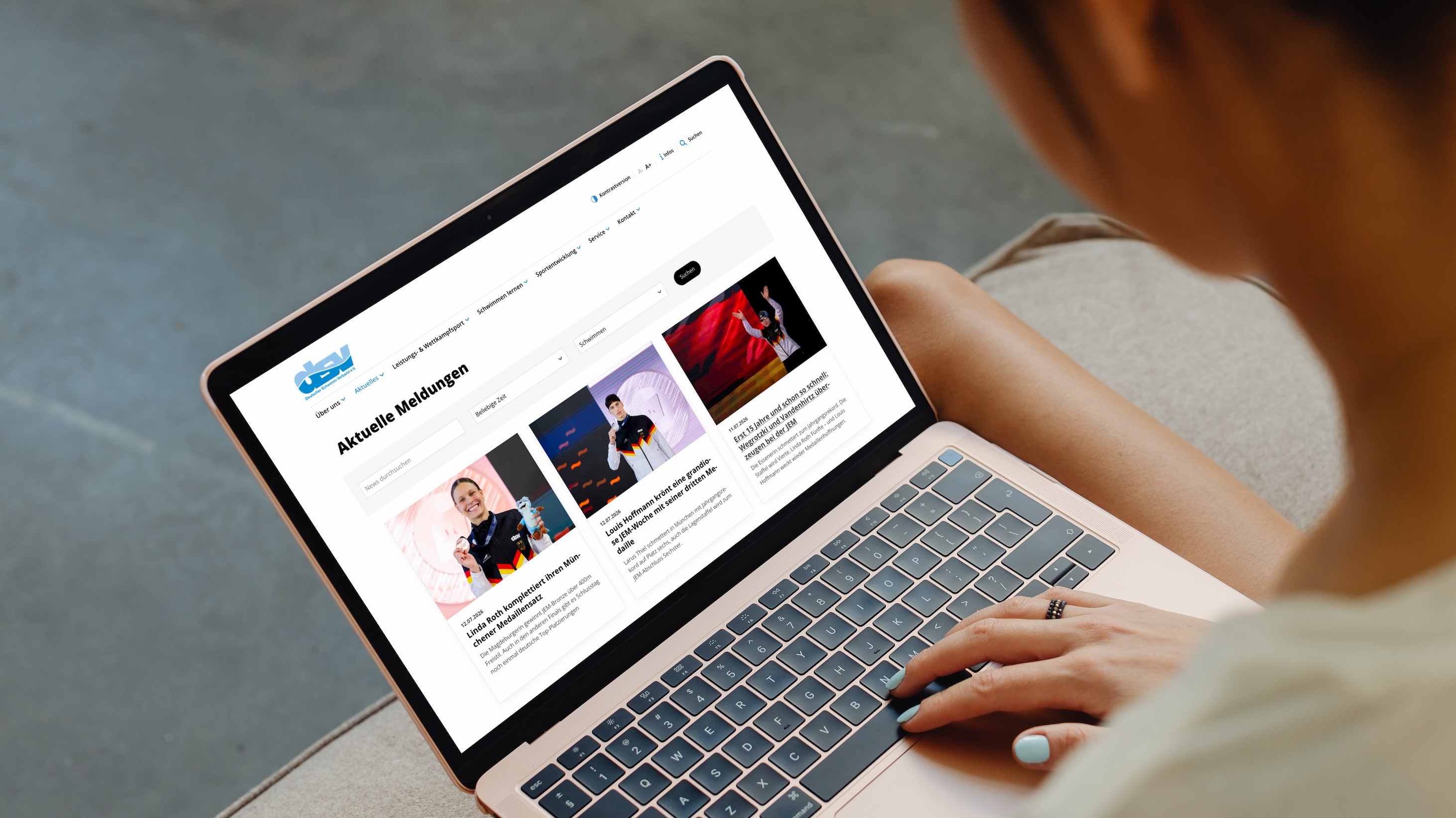 Newsroom Schwimmverband Laptop NETZCOCKTAIL-Newsroom: Frau liest auf ihrem Laptop aktuelle Meldungen und Wettkampfergebnisse eines Schwimmverbands